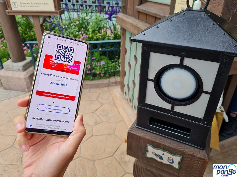 Móvil con el Disney Premier Access de Disneyland Paris junto a la máquina para escanear el código QR