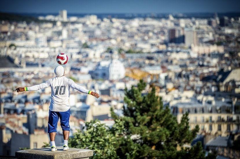Hombre jugando con un balón en Montmartre con vistas a París