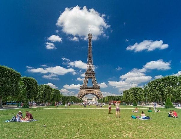 Campo de Marte en París frente a la torre Eiffel con gente disfutando del buen tiempo