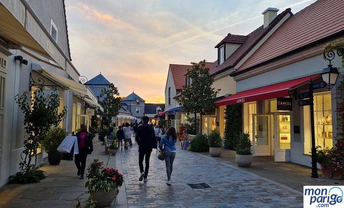 Anochecer en la calle con tiendas del outlet de La Vallée Village junto a Disneyland Paris