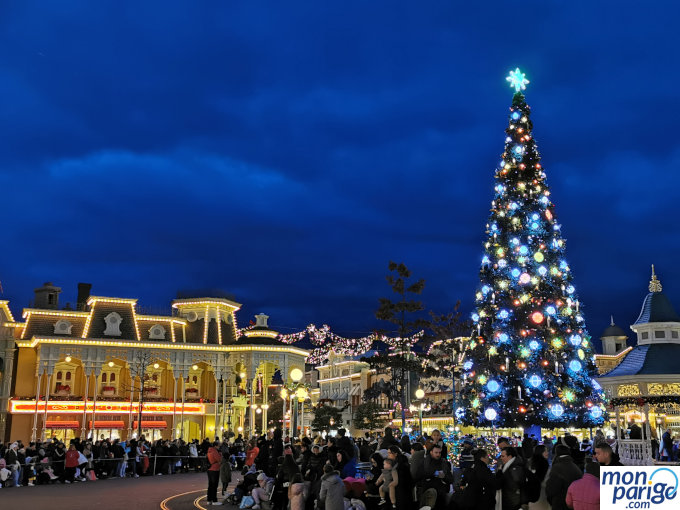 Árbol de Navidad y otros edificios iluminados y decorados en la Navidad de Disneyland Paris