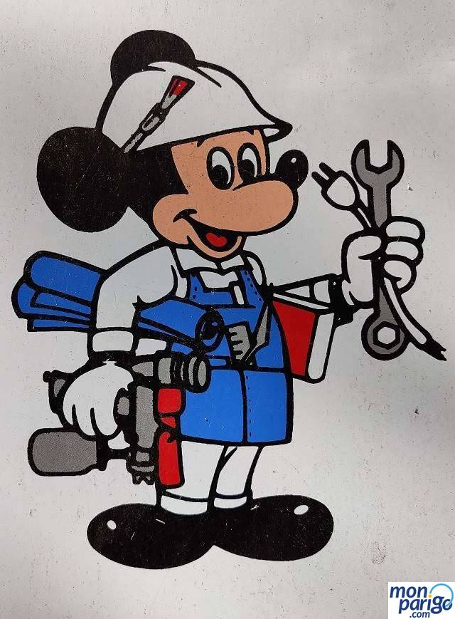 Dibujo de Mickey con casco, una llave inglesa, un plano y herramientas