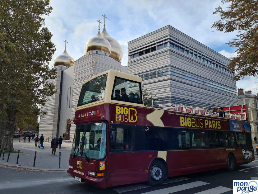 Autobús turístico descapotable de la compañía Big Bus frente a una iglesia de París