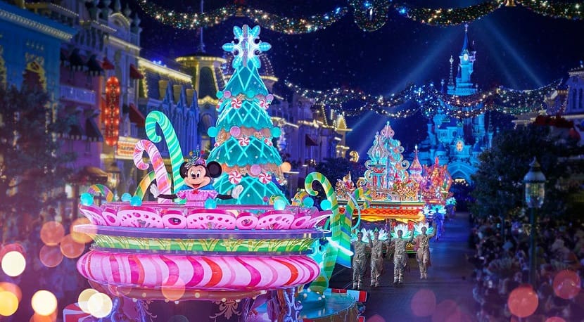 Carrozas iluminadas y bailarines desfilando en la cabalgata de Navidad en Disneyland Paris