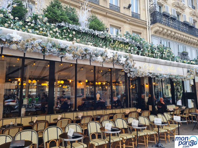 Sillas de mimbre y mesas redondas en la terraza del Café du Nord en París