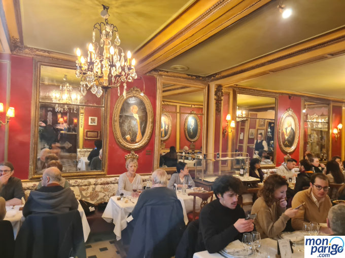 Comedor del Café Procope en París decorado con lámparas y cuadros clásicos
