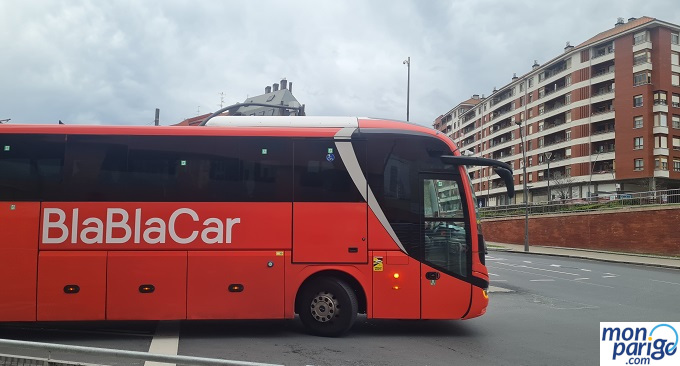 Cómo llegar a París en autobús de larga distancia Autobús rojo de la compañía BlaBlaCar circulando por la carretera rumbo a París
