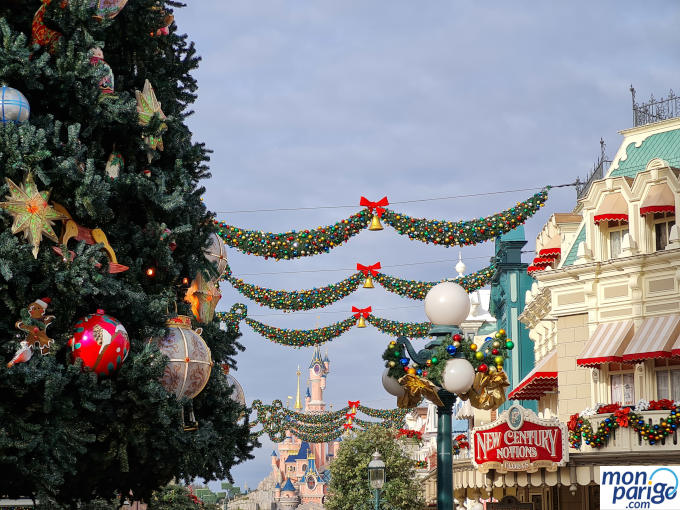 Árbol de Navidad con adornos y guirnaldas entre edificios de Disneyland Paris