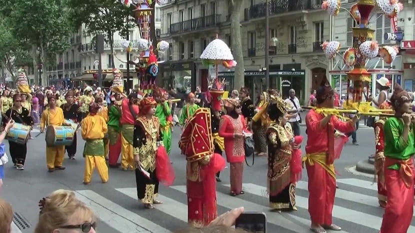 Personas de origen asiático con ropa tradicional en una calla de París
