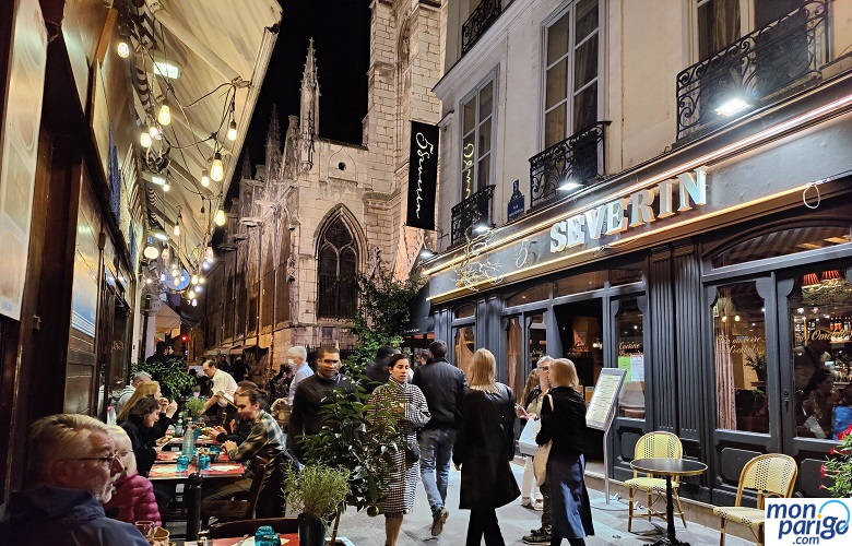 Gente cenando en las terrazas de unos restaurantes de París