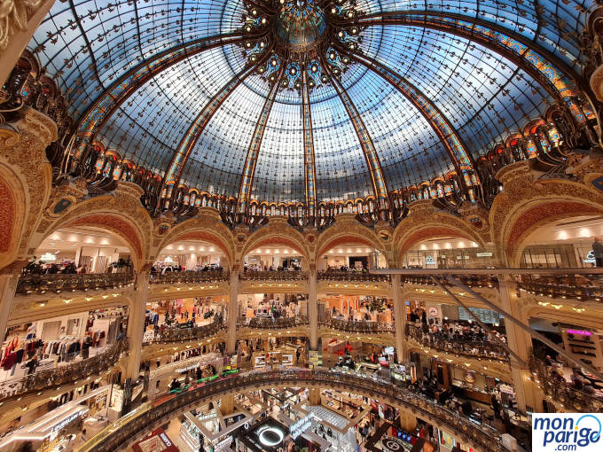 Tiendas alrededor de la cúpula de Galeries Lafayette Haussmann en París y pasarela de cristal
