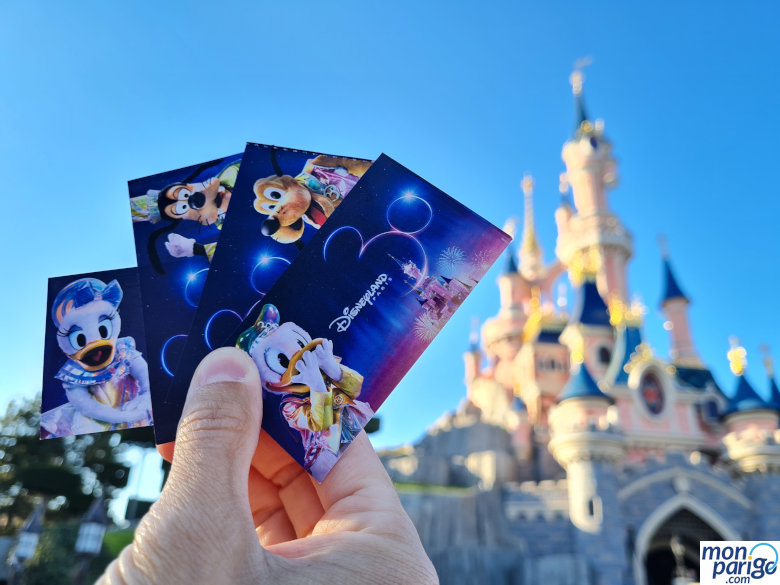Mano sujetando cuatro entradas a Disneyland Paris
