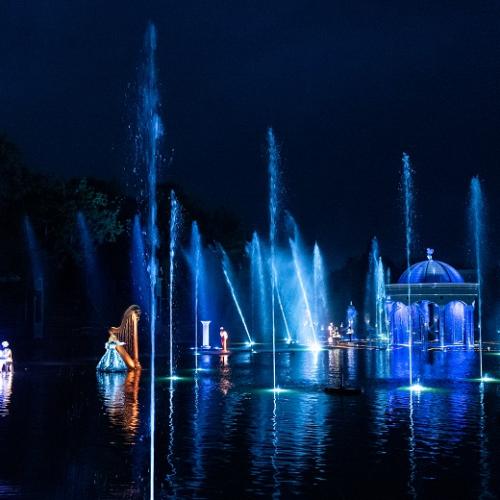 Lago iluminado con chorros de agua y bailarines sobre el agua
