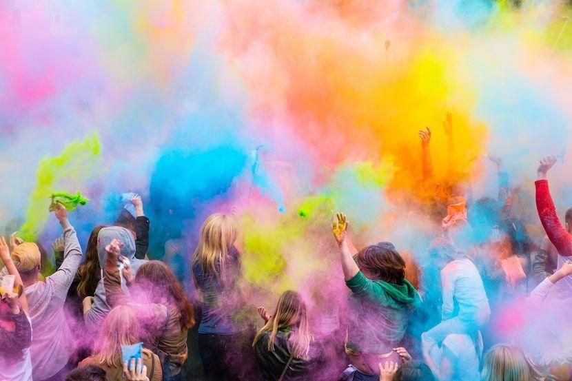 Grupo de gente lanzando polvos de colores en la fiesta del Holi en París