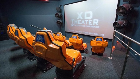 Sala con butacas naranjas y una pantalla de cine en el hotel Explorers de Disneyland Paris