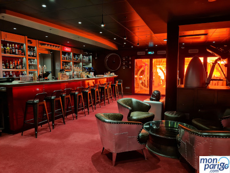 Barra de bar y sillas sobre una moqueta roja en el Hotel Station Cosmos de Futuroscope