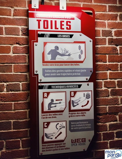 Cartel con las instrucciones descritas en francés sobre cómo conseguir puntos en Spider-Man W.E.B. Adventure de Disneyland Paris