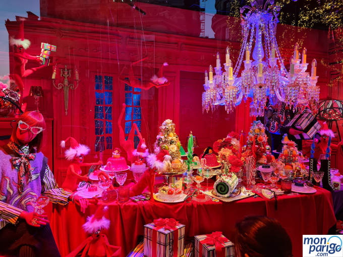 Escaparate de Navidad decorado con muñecos, una mesa y una lámpara de araña de cristal