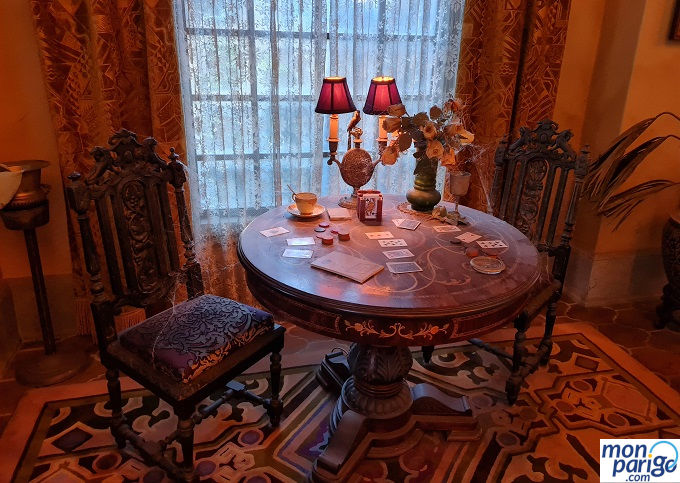 Dos sillas y una mesa con un candelabro, flores y cartas en la Tower of Terror de Disneyland Paris (Torre del Terror)