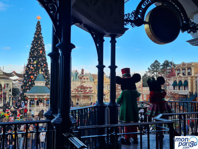 Mickey y Minnie de espaldas saludando al público desde lo alto durante la temporada de Navidad en Disneyland Paris