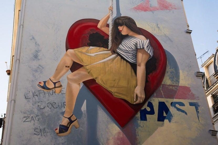 Pintura mural "L'attrape Coeur" en una pared de uno edificio de París.