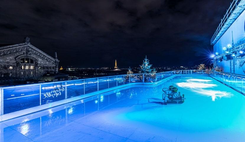 Pista de patinaje sobre hielo en París iluminada de noche con color azul