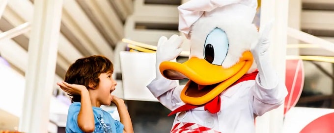 Pato Donald vestido de cocinero saludando a un niño en Walt Disney World Resort