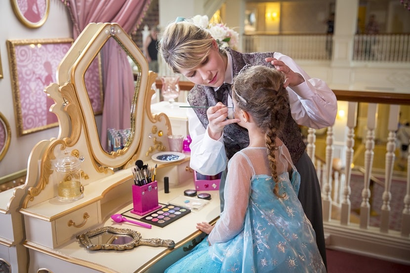 Una maquilladora convirtiendo a una niña en princesa por un día en Disneyland Paris