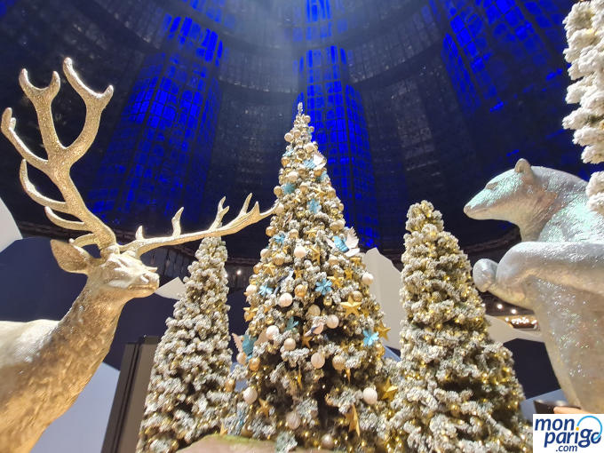 Árboles de Navidad, osos y renos bajo una cúpula de cristal