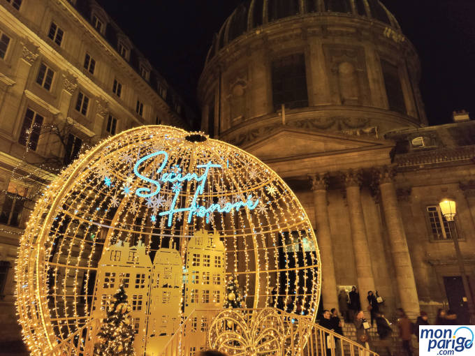 Gran bola de Navidad iluminada frente a una iglesia en París