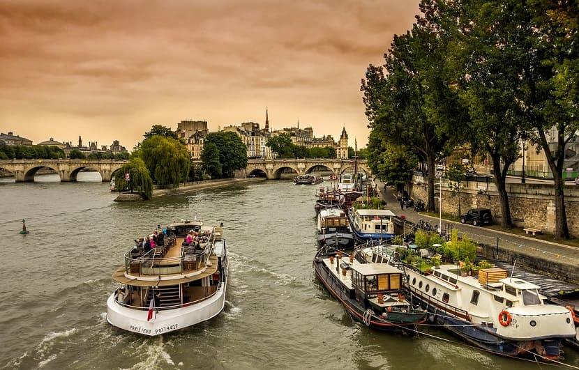 Barxos navegando por el río en París al atardecer