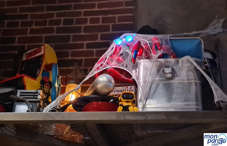 Juguetes y otros objetos en una balda con telarañas en Spider-Man W.E.B. Adventure de Disneyland Paris