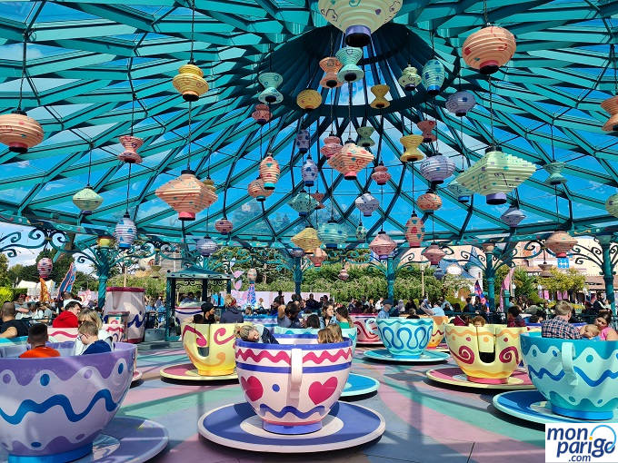 Tazas de té con gente dentro dando vueltas bajo una cúpula de cristal en Disneyland Paris