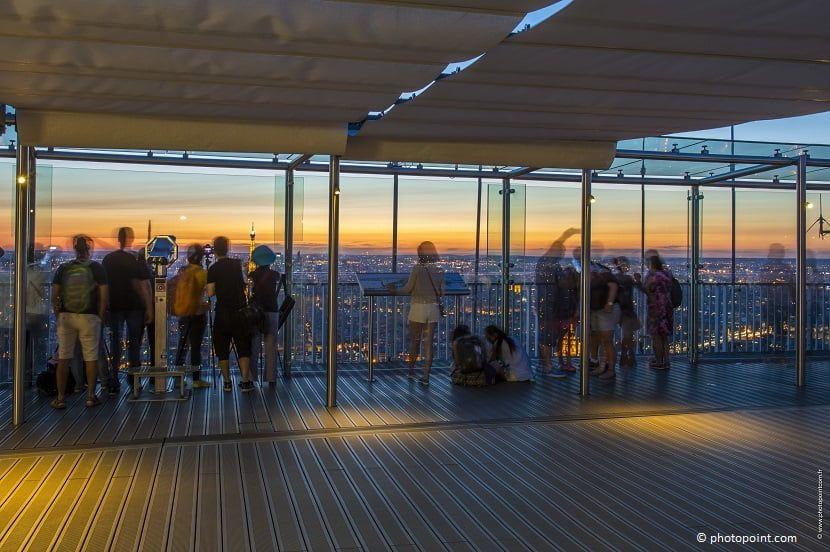 Turistas disfrutando de las vistas al anochecer desde la torre Montparnasse