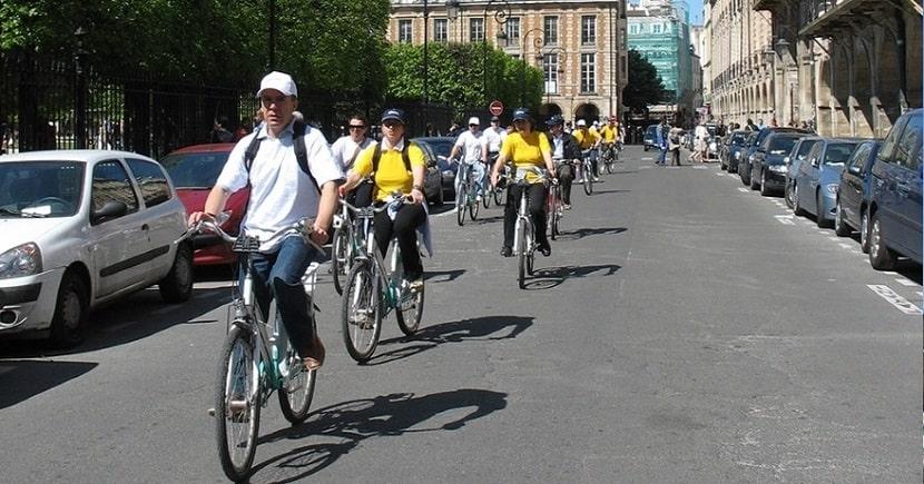 Grupo guiado en bici por las calles en el medio del tráfico de París