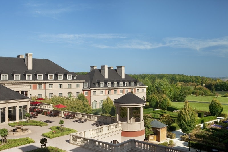 Fachada y jardines franceses del Dream Castle Hotel, alojamiento recomendado cerca de Disney.