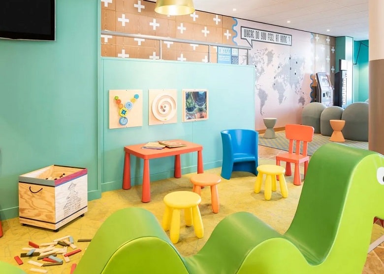 Mesas y sillas de colores y juegos para niños en el ApartHotel Adagio Marne la vallée Val d’Europe de Disneyland Paris